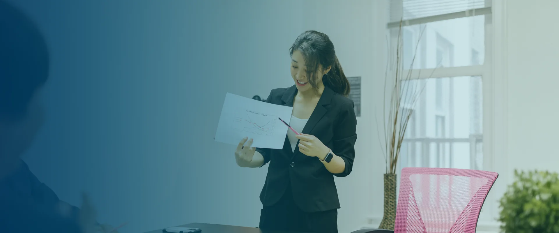 Team member presenting a printed chart to colleagues at a planning meeting table