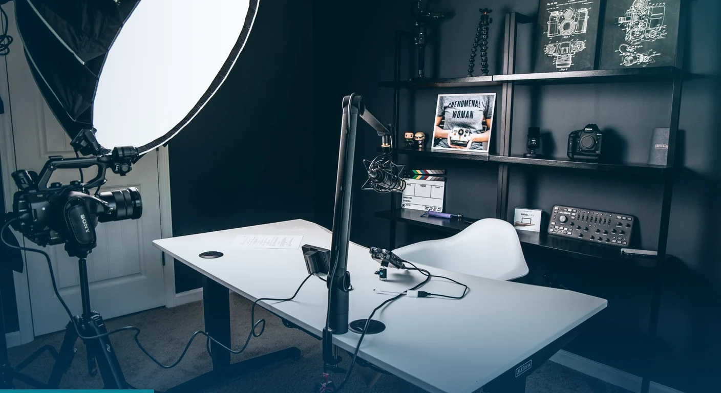 Home production studio with a camera, softbox light, microphone arm and white desk