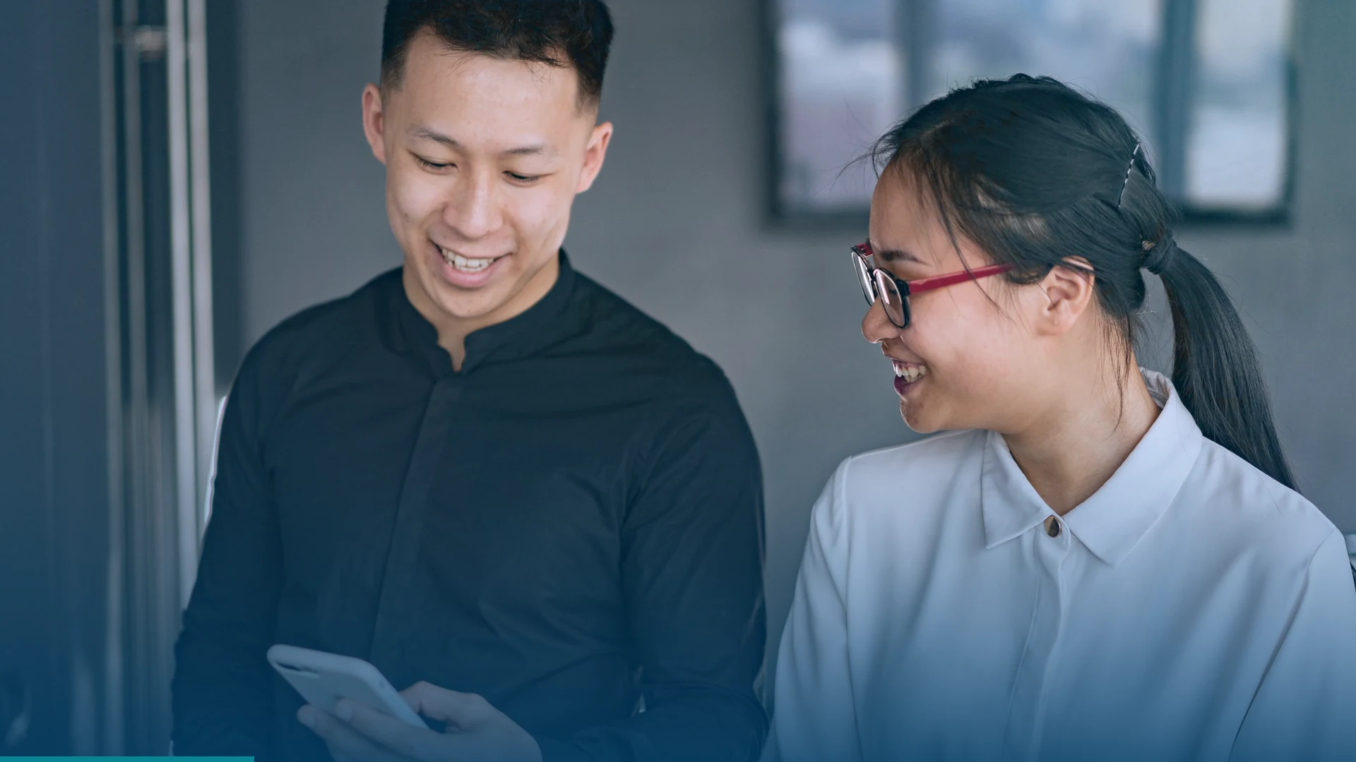 Digital marketing team reviewing social media content on a smartphone in a modern office.
