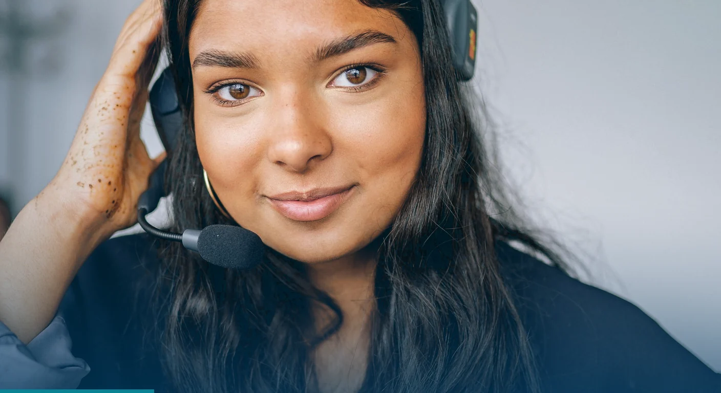 Smiling woman wearing a headset with a microphone, looking straight at the camera