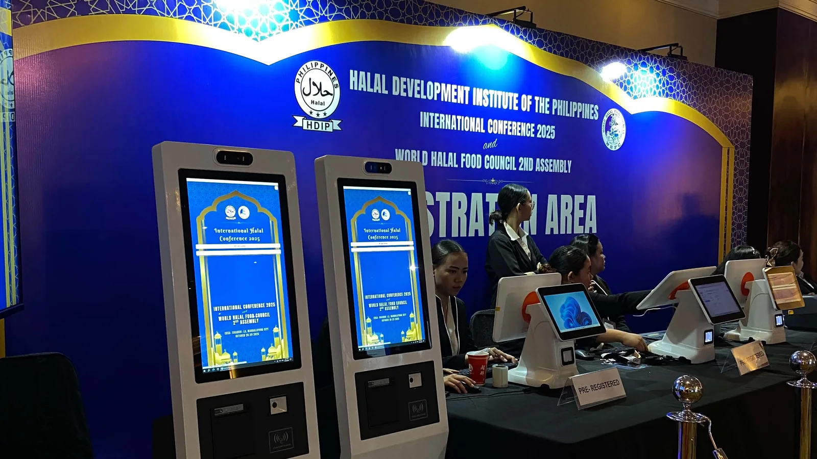 Two self check-in kiosks with QR scanners at an event registration area
