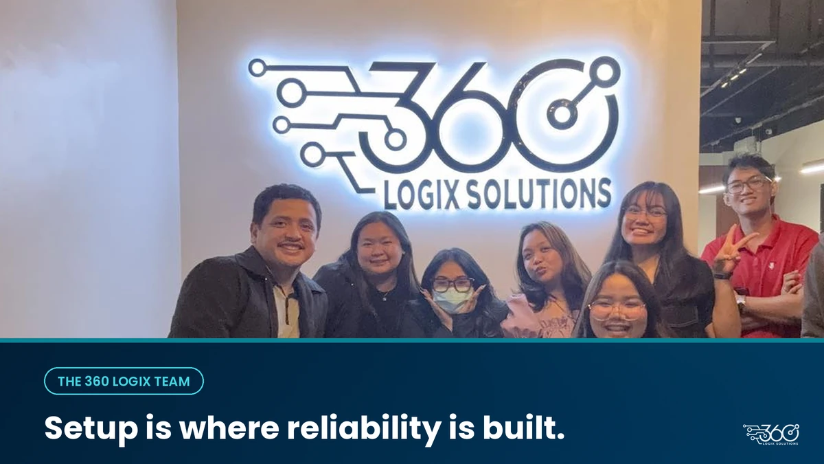 The 360 Logix team standing in front of the lit company logo wall at the office