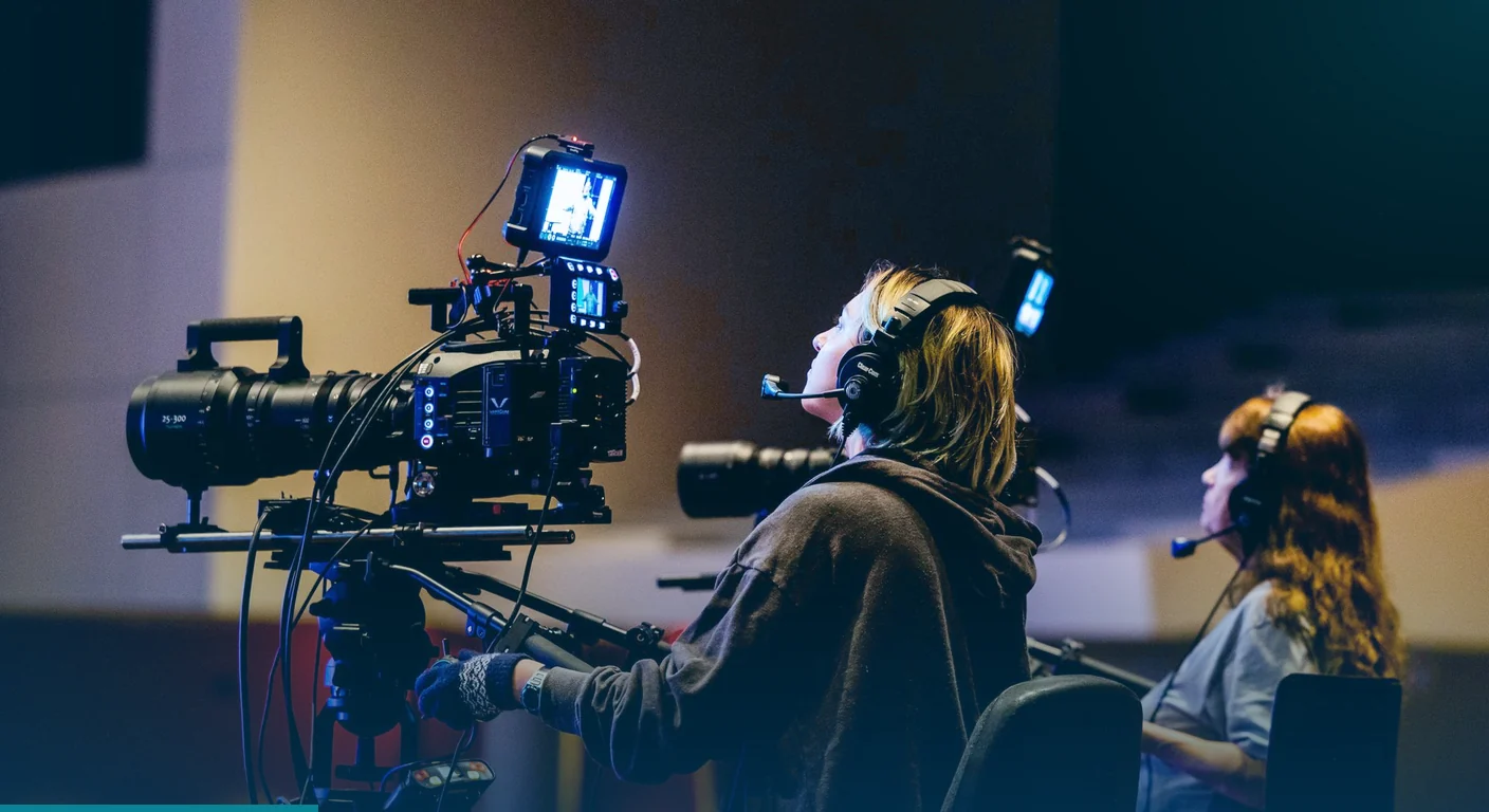 Camera operators wearing headsets filming with cinema cameras during a production