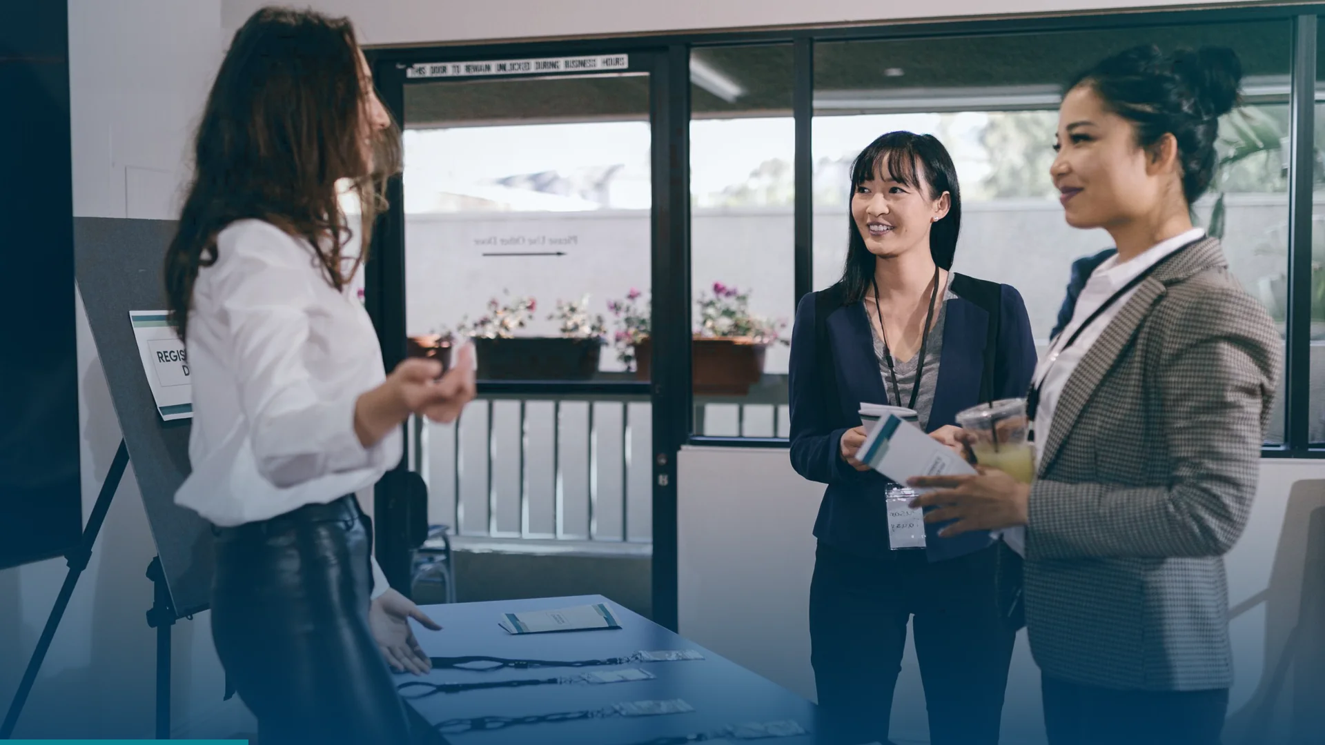 Attendees picking up badges and lanyards at an event registration desk