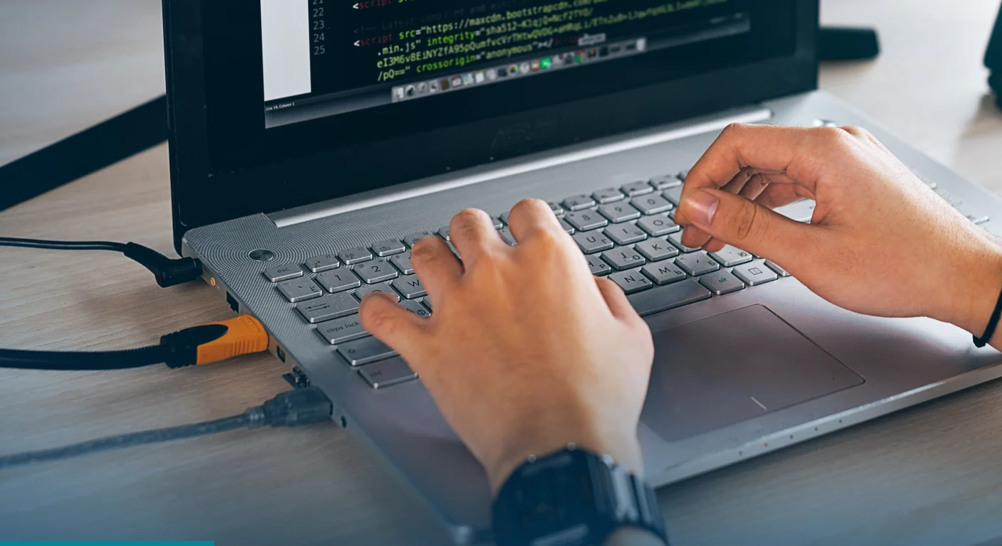 Developer typing code on a laptop during website development in the Philippines
