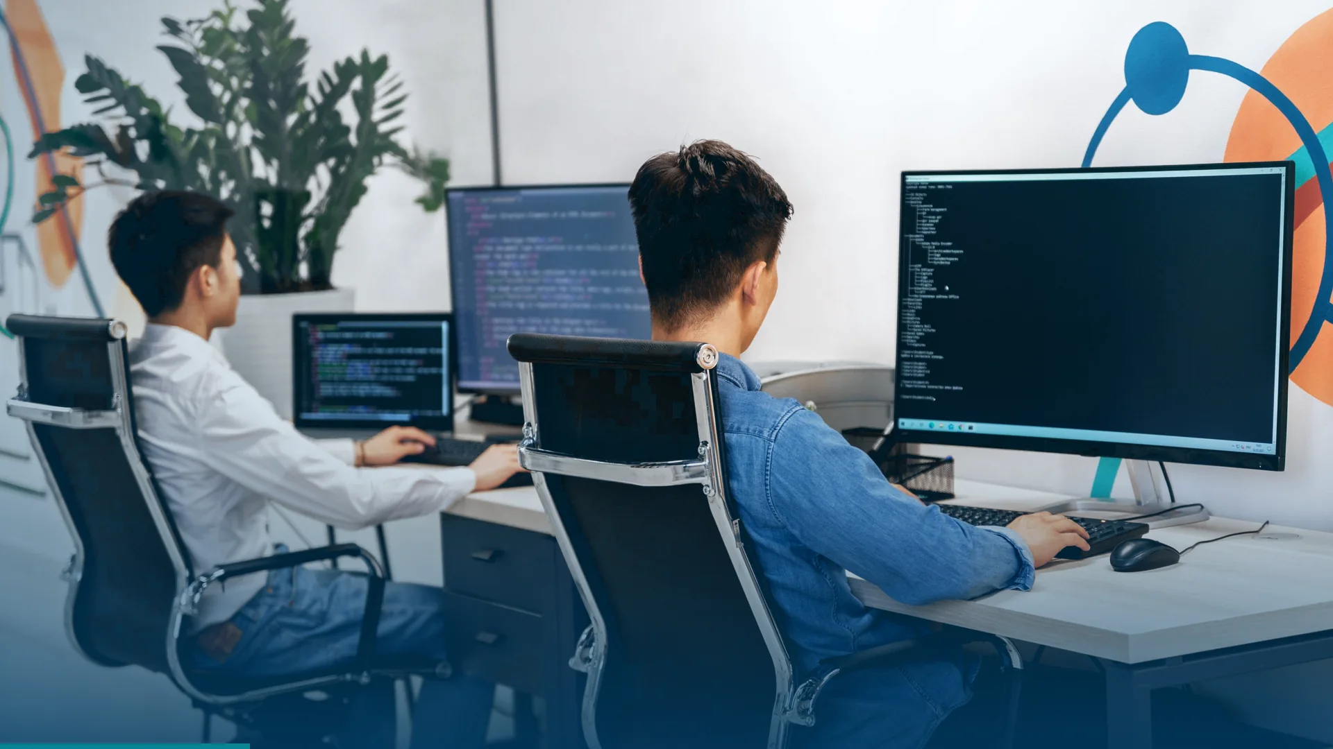 Web developers working on a website at desktop monitors in a modern office